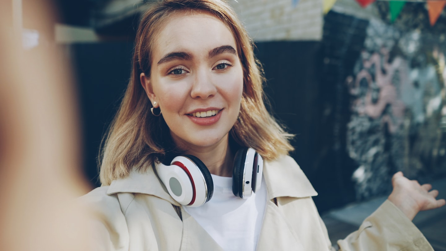 Smiling online creator using phone and ring light to build fan engagement and improve camming income