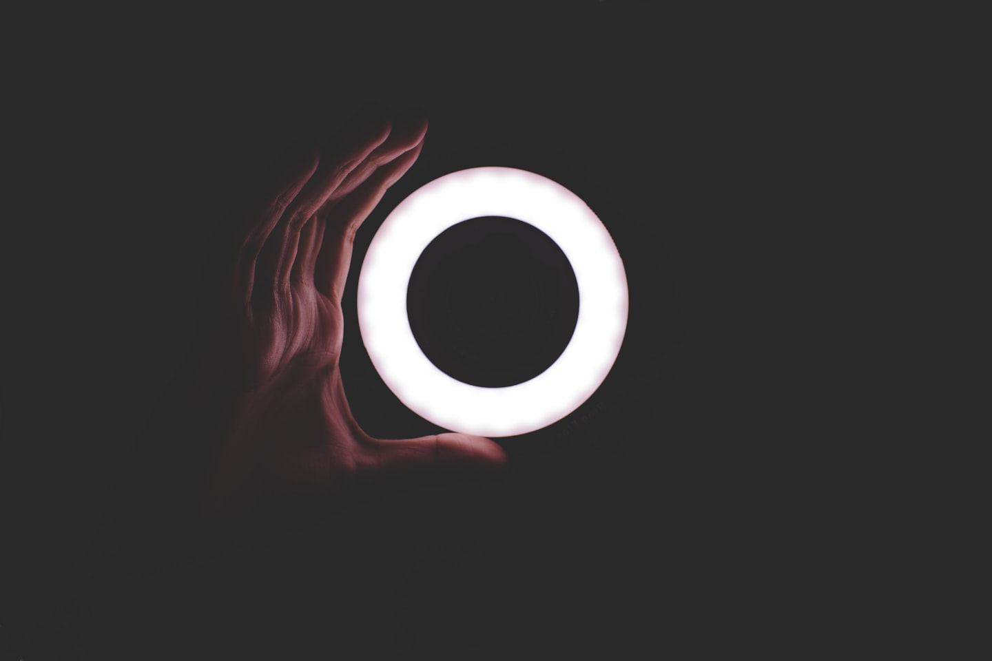 A creator in a ring light setup with a camera and monitor, illustrating basic lighting for a professional live stream