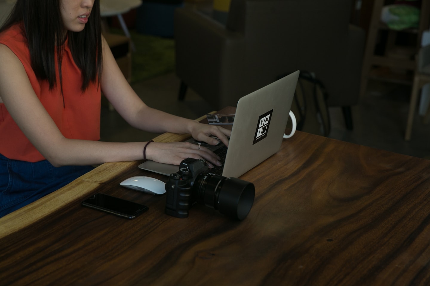 Woman typing on laptop with camera on table