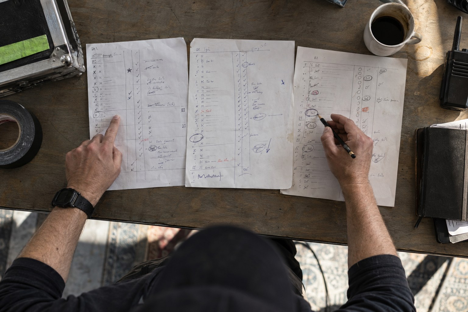 Operator comparing handwritten results from three live shows