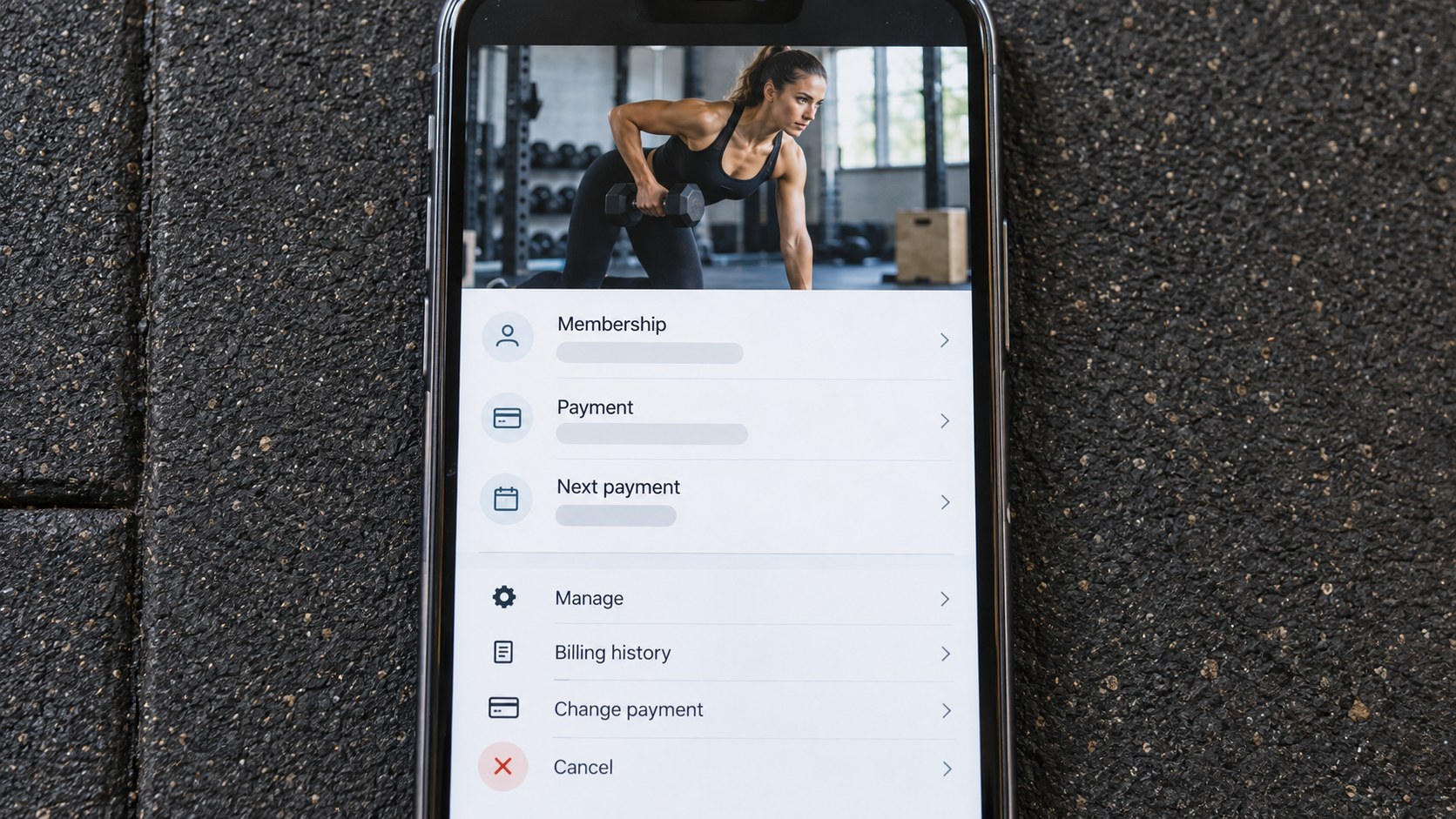 Close view of a phone displaying fitness membership payment controls beneath a photo of an athletic woman lifting a dumbbell.